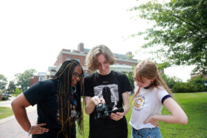 From left: Alanah Cleare ’25, who earned a degree in marketing from UMW in May; junior Owen Wheeler; and senior Chloe Adler review recently captured footage for a project aimed at assessing the usefulness of AI in filmmaking. The trio conducted research under the guidance of Assistant Professor of Communication and Digital Studies J.D. Swerzenski. They were among four groups that participated in this year’s Arts, Humanities and Social Sciences Summer Institute. Photo by Karen Pearlman.